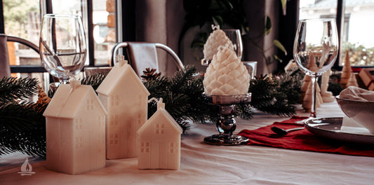 Weihnachtlicher Tisch mit Haeuser Kerzen im Vordergrund