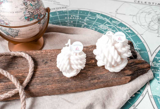 2 cremeweiße Tau-Knoten Kerzen aus Rapswachs Globus und Seekarte im Hintergrund