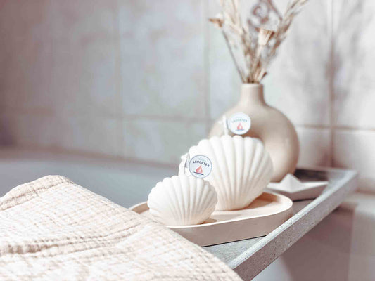 große und kleine Muschelkerze im Badezimmer Handtuch im Vordergrund
