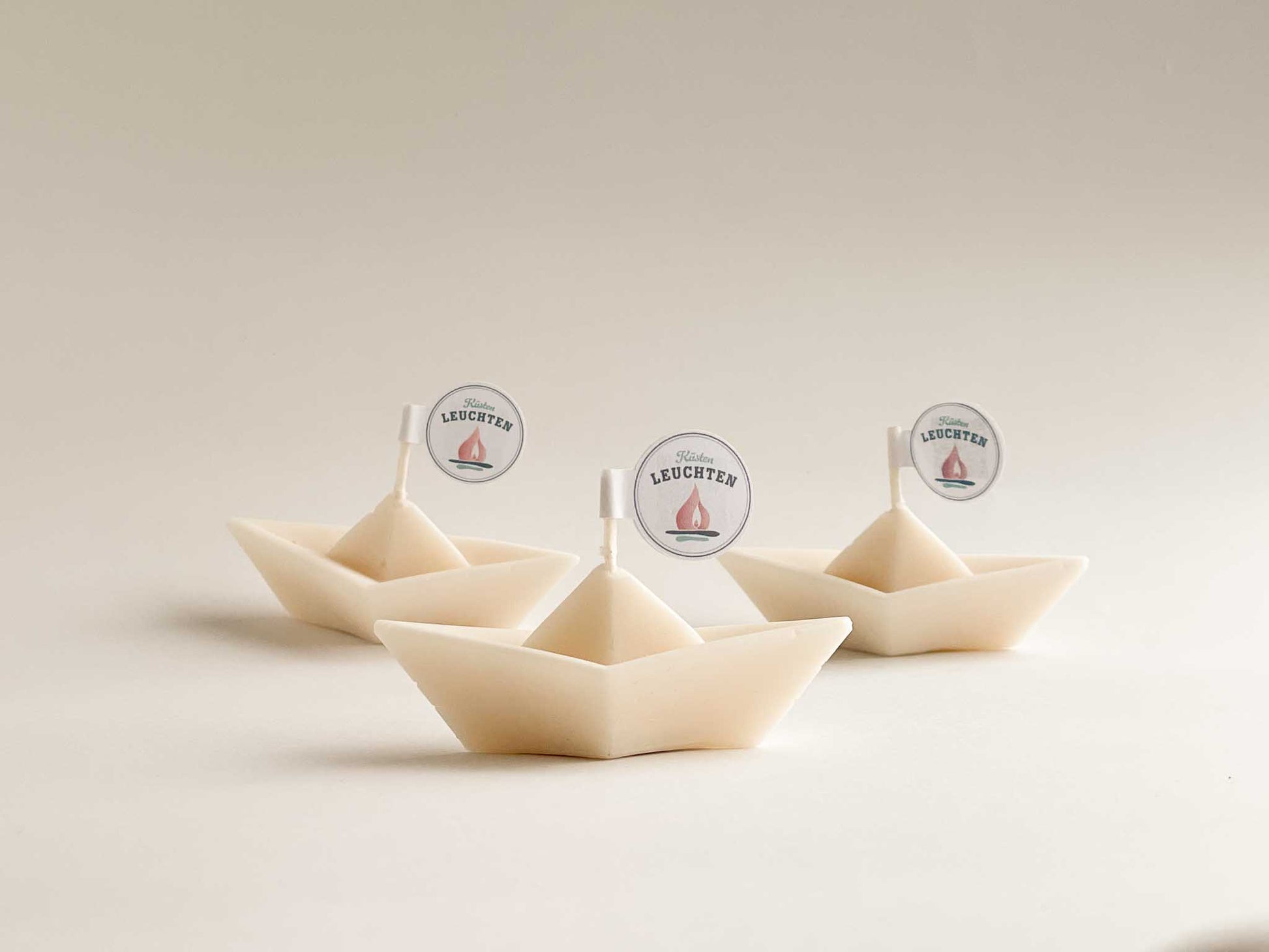 3 cremeweiße Schiffchen aus Rapswachs vor weißem Hintergrund