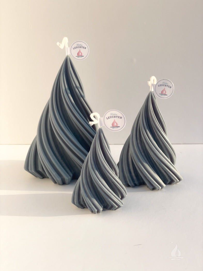 3 gedrehte Tannenbaumkerzen vor weißem Hintergrund