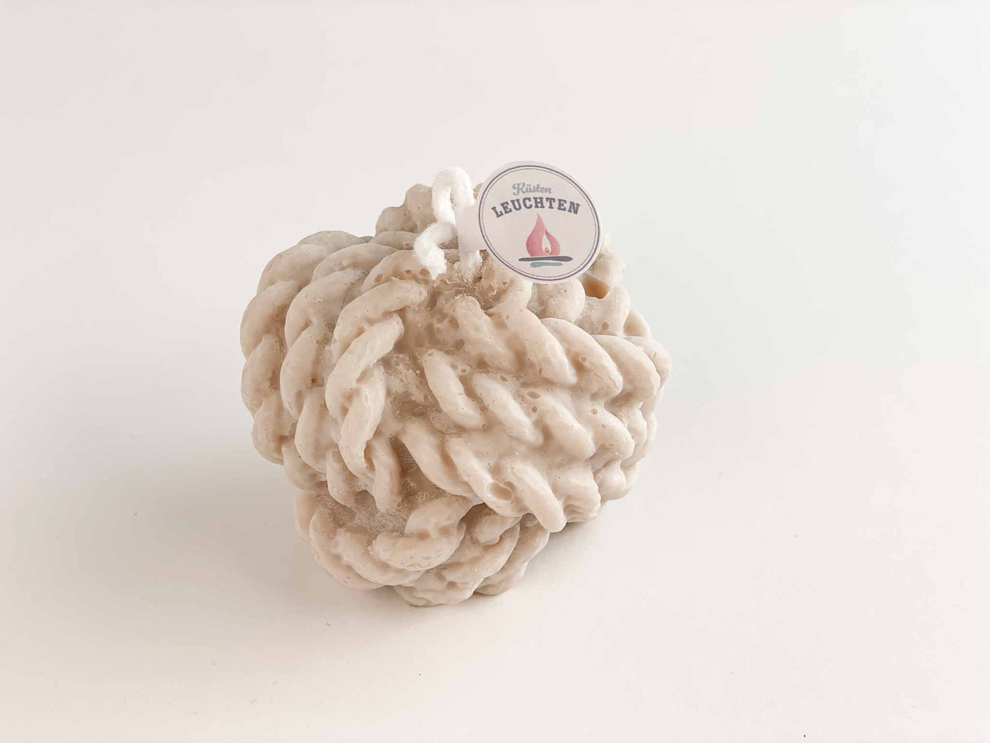 Nahaufnahme große Tau-Knoten-Kerze in grau-beige