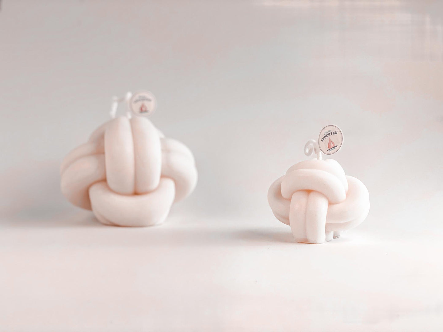 zwei Knotenkerzen in cremeweiß vor weißem Hintergrund. Geschenk für Männer und Seemänner