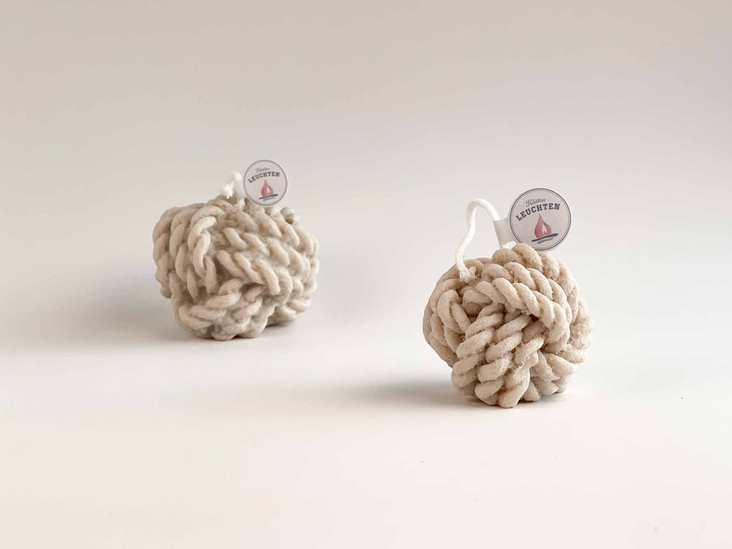 kleiner Tau-Knoten in grau-beige im HIntergrund großer Tau-Knoten