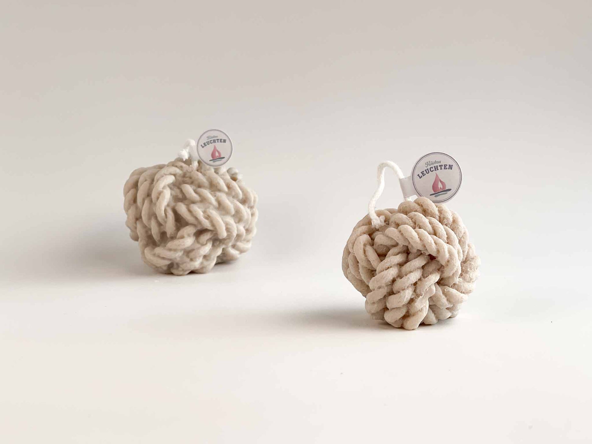 kleiner Tau-Knoten in grau-beige im HIntergrund großer Tau-Knoten