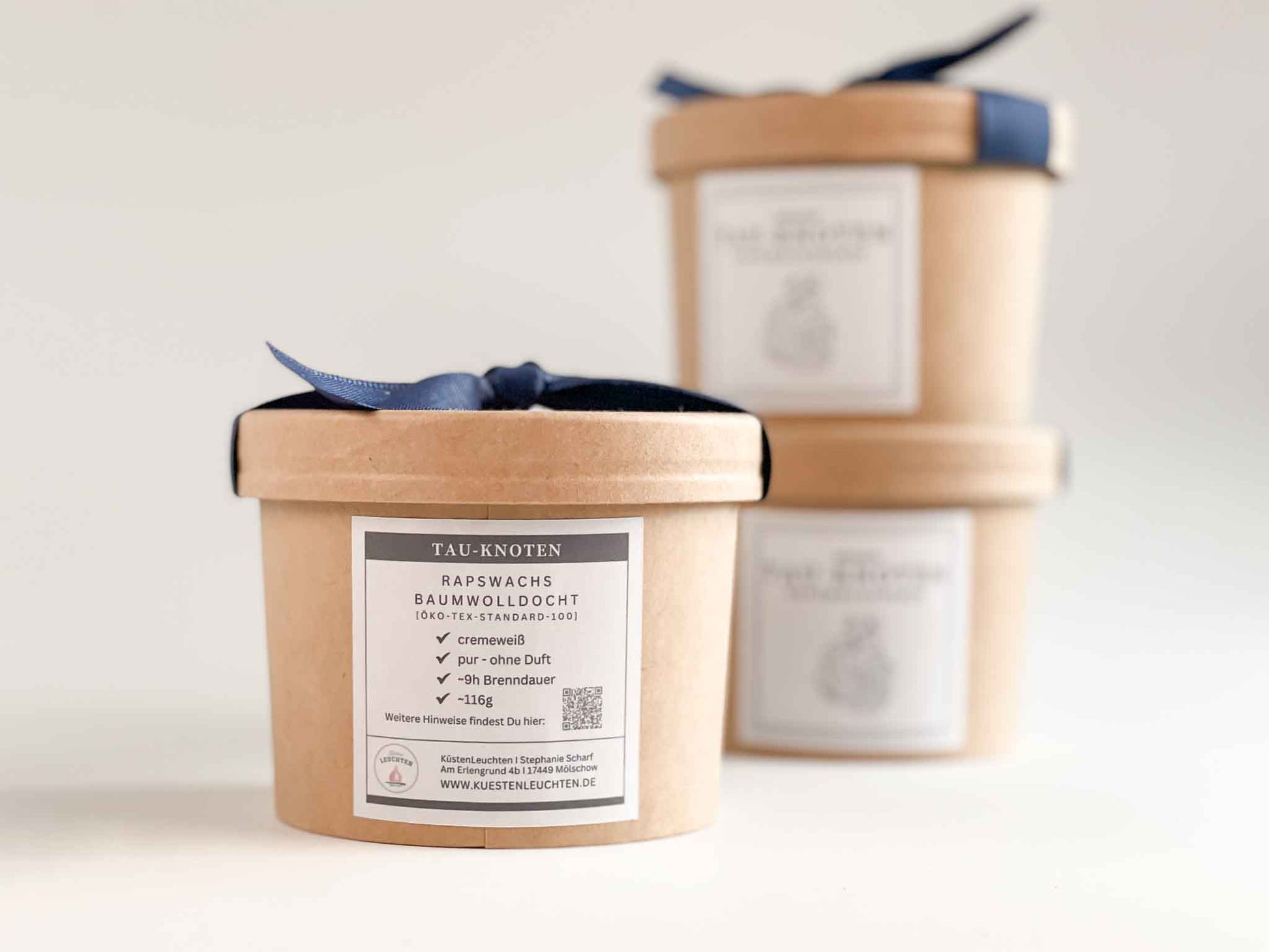 Rückseite der Geschenkverpackung der Tau-Knotenkerze im Hintergrund 2 weitere Verpackungen