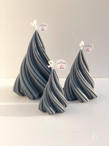 3 gedrehte Tannenbaumkerzen vor weißem Hintergrund