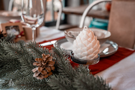 weihnachtlicher Tisch mit cremeweißer Zapfenkerze